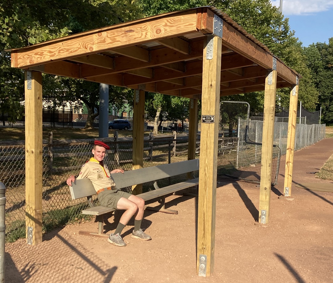 Boy Scout Max Coey sitting under the newly built baseball dugout