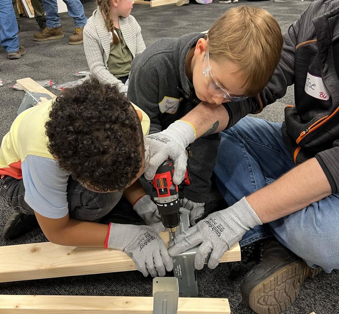 Kids building a workbench with the help of a parent