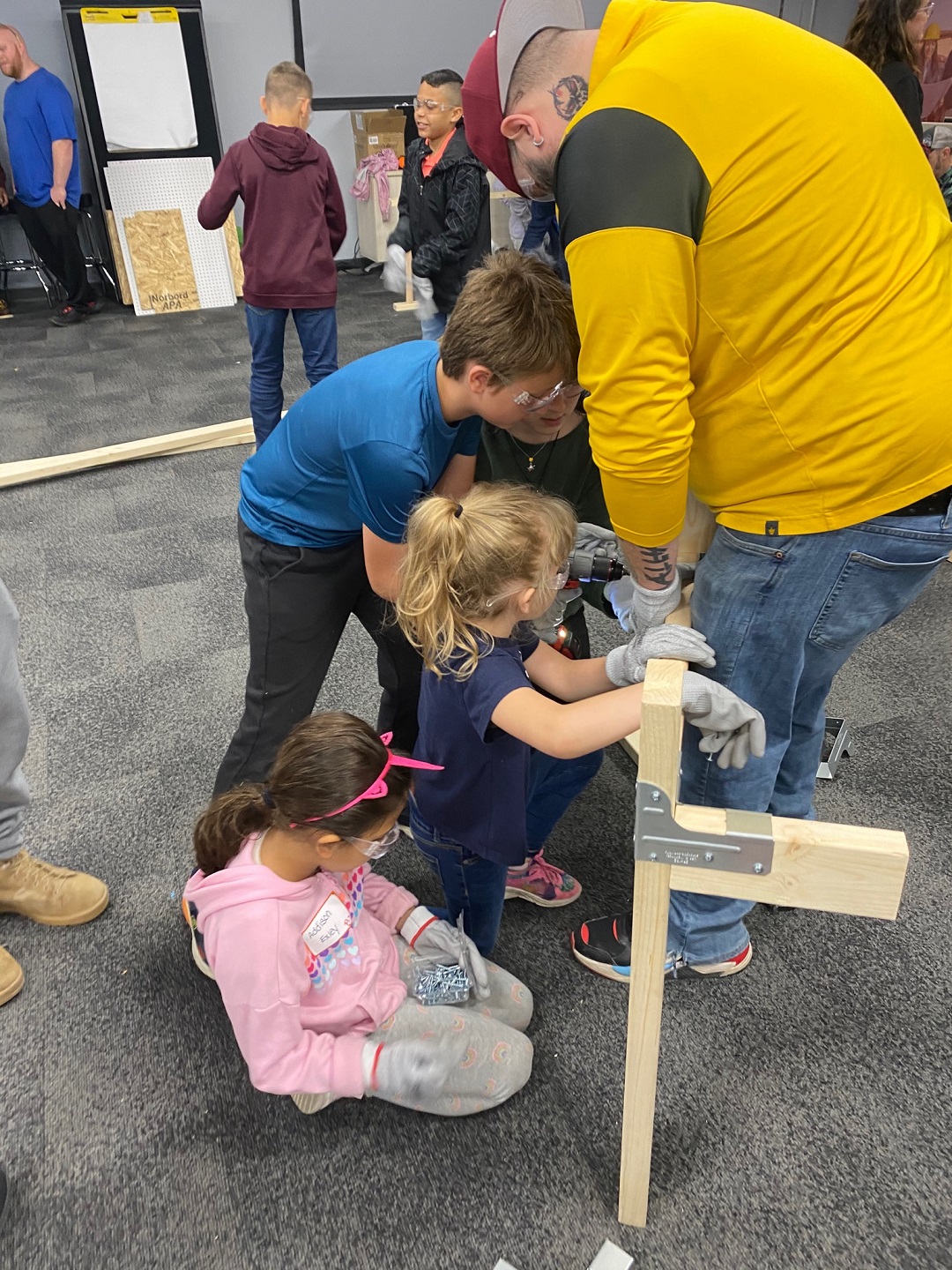 Parent with some kids building a workbench