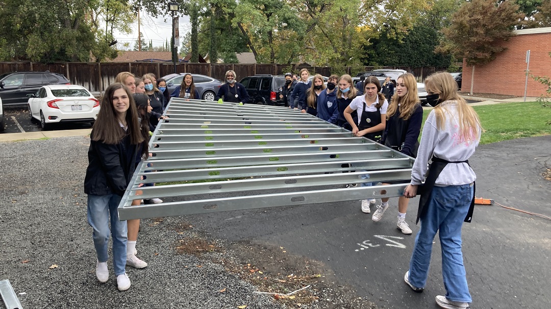 Carondelet Students carrying a wall for the tiny house