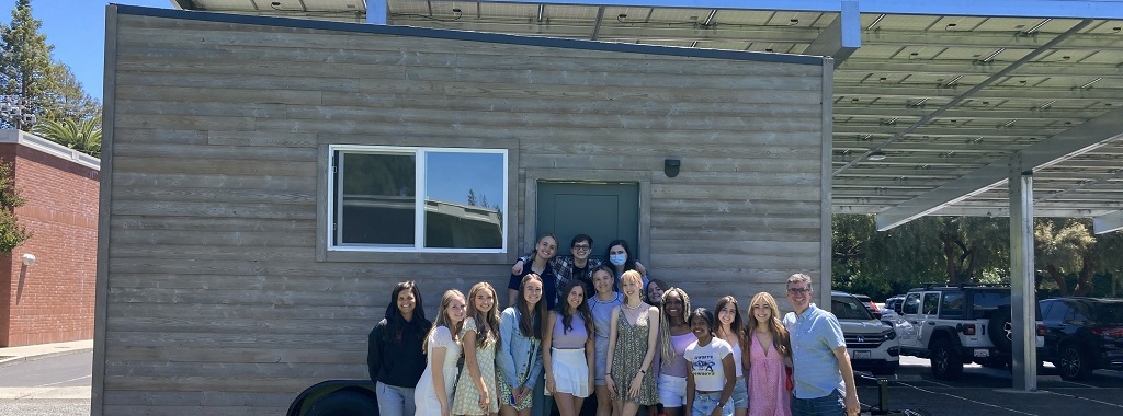 Group photo of students in front of completed tiny house