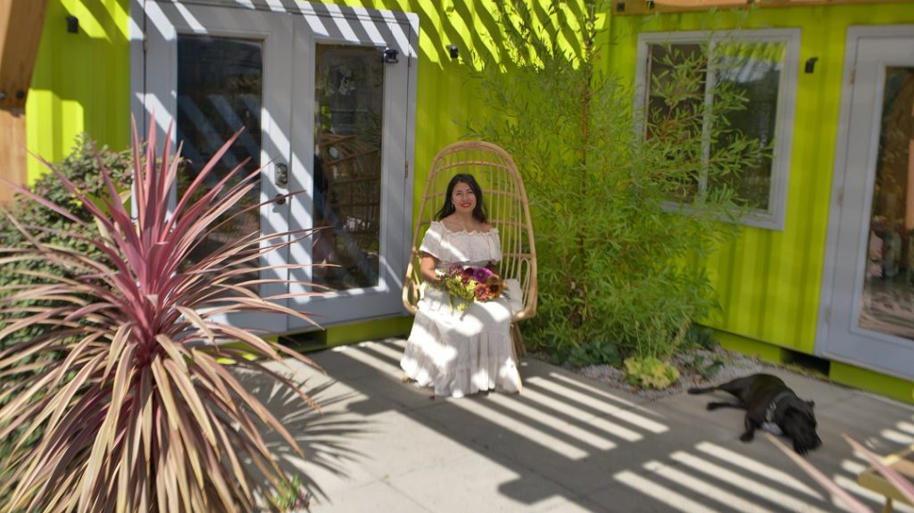 Pilar sitting in front of her flower shop