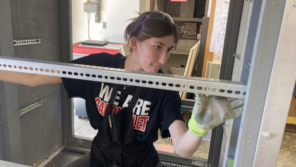 Carondelete student working building the shelves for the rest station