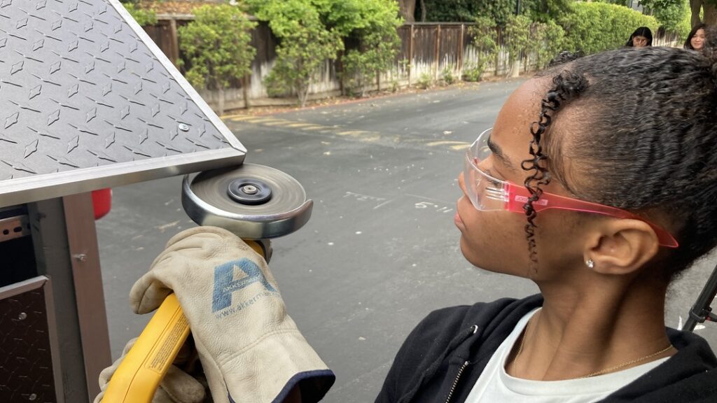 Carondelete student using a power tool and cutting metal